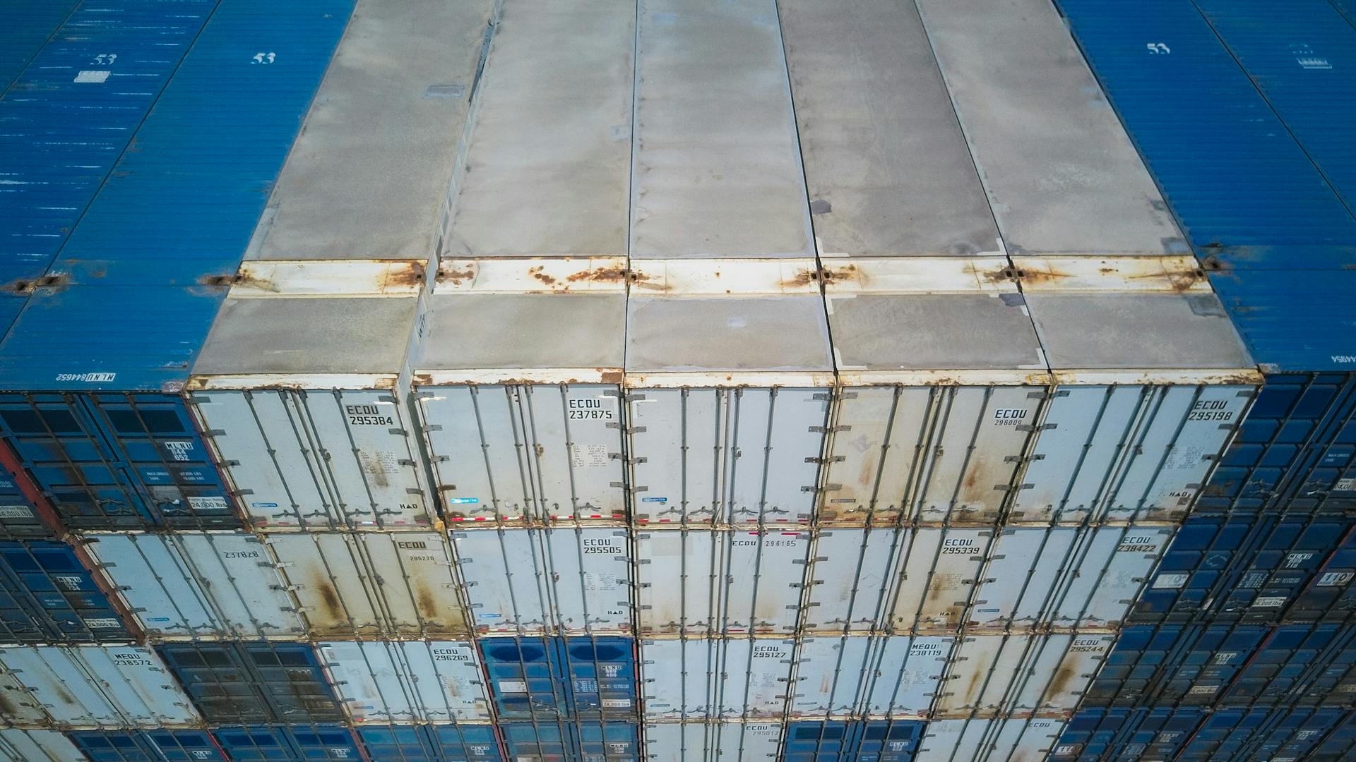 High angle shot of multiple stacked shipping containers showcasing global logistics and trade.
