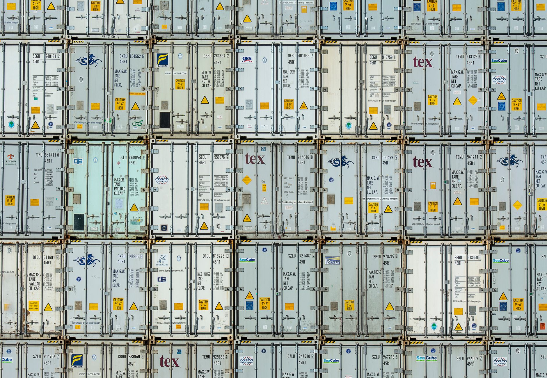 A patterned array of industrial shipping containers stacked in a storage terminal.