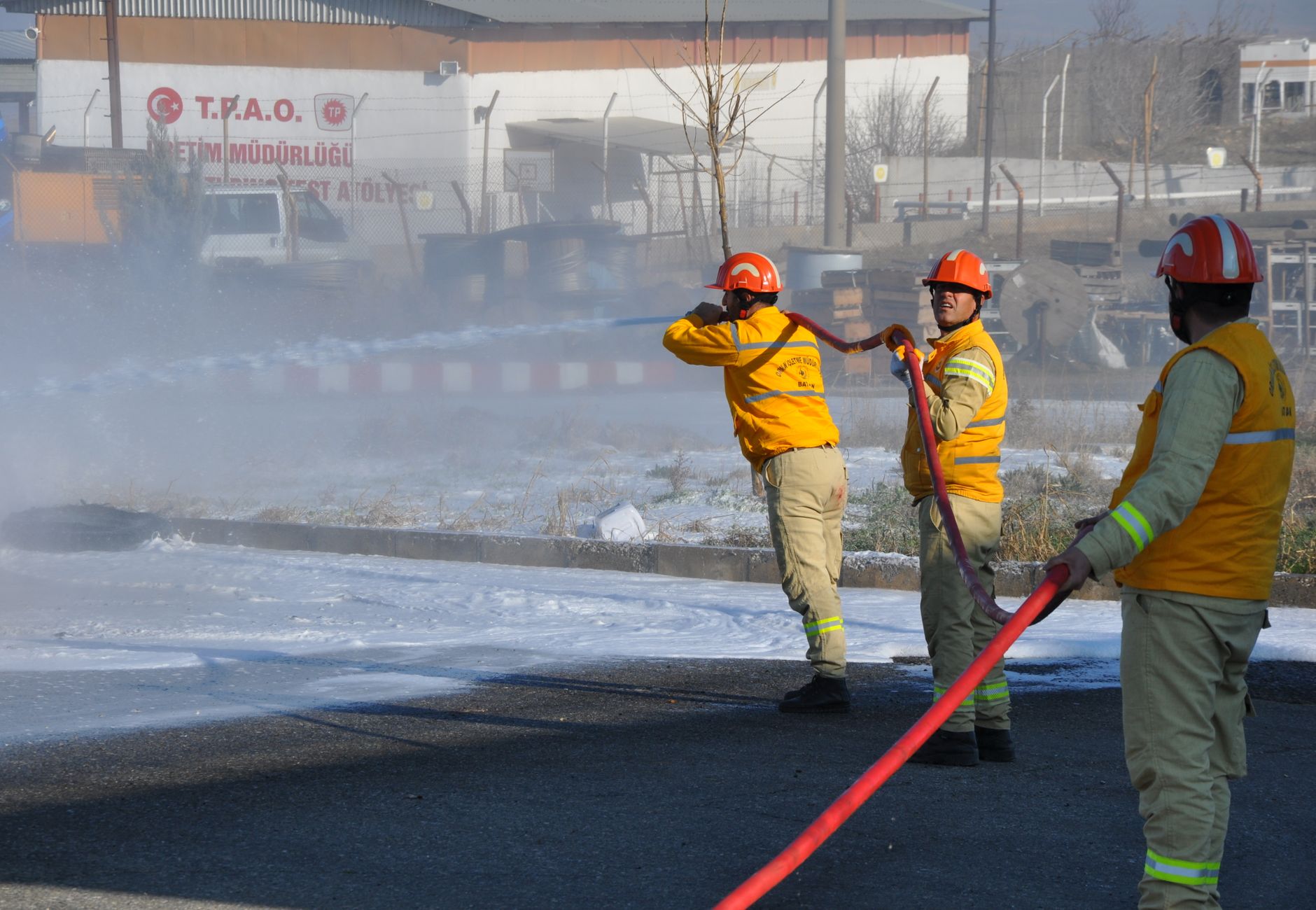 Firefighters working to extinguish a fire using a hose in Batman, Türkiye.